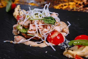 Pieces of meat on a black board with pea puree
