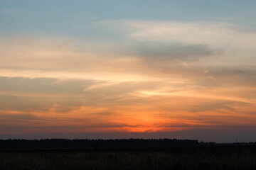 Fototapeta premium Sunset inMoscow oblast, Russia. Blue clouds. Orange sun strip.