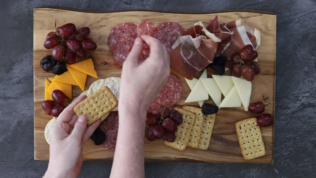 Eating from a Charcuterie Board with Meats and Cheeses shot from Above