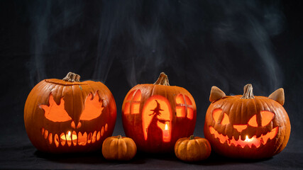 Illuminated jack o lantern halloween pumpkins, on black background	