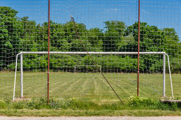 Soccer goal with net in rural field with grass