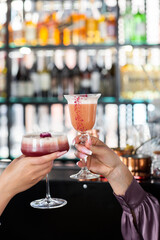 Closeup of two women holding summer fresh cocktails. Summertime concept. Cheers.