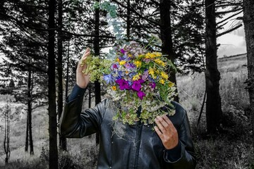 Floreciendo - hombre con flores en la cara - hombre con flores en el bosque - máscara de flores