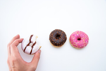 Hand taking a piece of delicious doughnuts on a white background with free space for text