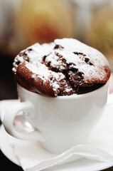 Chocolate muffin in a cup sprinkled with powdered sugar