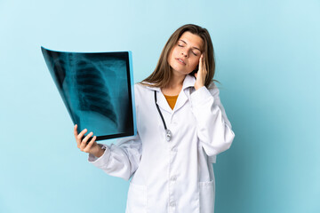 Young doctor woman holding radiography over isolated background with headache