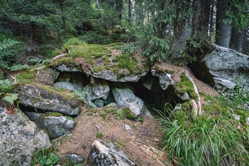 large stone cave in the woods. mysterious places in nature