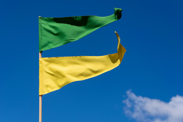 green and yellow pennants fluttering in the wind in the blue sky. Patriotism