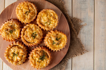 Hot tasty muffins with vegetables and cheese on wooden board. Recipe for autumn seasonal dish. Delicious homemade cakes for healthy diet.