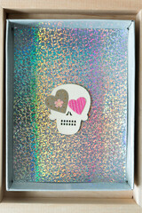 halloween themed wooden shapes with hearts on a glittery paper background inside a cardboard box on wood