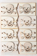 wooden skull and crossbones arranged on plain tags on a wooden background