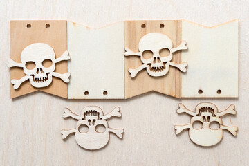 wooden skull and crossbones arranged on plain tags on a wooden background