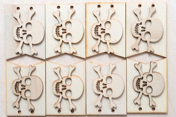 wooden skull and crossbones arranged on plain tags on a wooden background