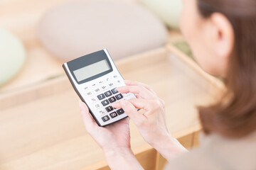 電卓を持つシニア女性　手元