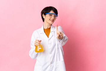 Young scientific woman isolated on pink background showing and lifting a finger