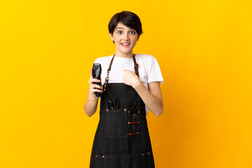 Hairdresser woman isolated on yellow background with surprise facial expression