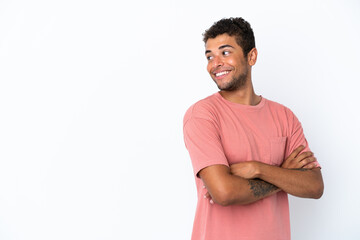Fototapeta premium Young handsome Brazilian man isolated on white background with arms crossed and happy