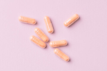Goji Berry (Wolfberry) capsules. Immune system support. Dietary supplement on pink paper background. Top view. Close up. 