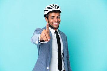 Young business Brazilian man with bike helmet isolated on blue background showing and lifting a finger