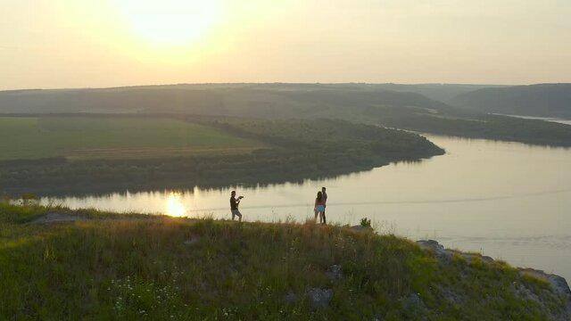 The man and woman taking photo on beautiful mountain above the river