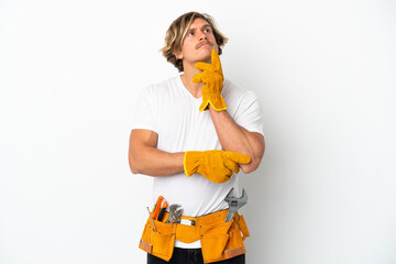 Young electrician blonde man isolated on white background having doubts while looking up