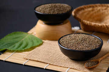 Perilla seeds in a black bowl with spoon, Healthy herbal seed ingredients in Asian food, Still Life
