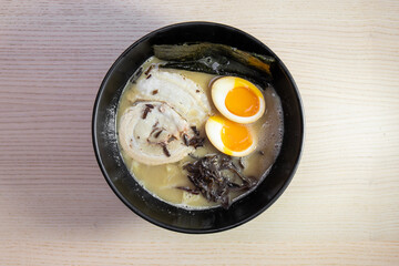 A bowl of tonkotsu ramen with pork slice and egg.