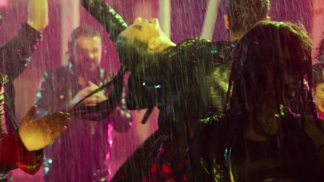 Footage Of A Crowd Or Group Of Young, Stylish Multi-ethnic People Dancing In The Rain . Colorful Outdoor Party At Raining Day . Dancers Having Fun Dancing At Party . Shot On ARRI ALEXA In Slow Motion