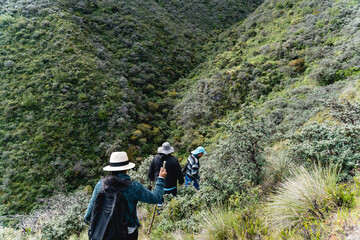 Small group of hikers walking in the mountains of the Andes towards a river