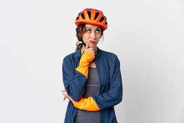 Young cyclist woman isolated on white background having doubts