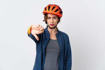 Young cyclist woman isolated on white background showing thumb down with negative expression