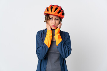 Young cyclist woman isolated on white background frustrated and covering ears