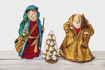 Two vintage santas with a decorative ceramic Christmas tree on white background.