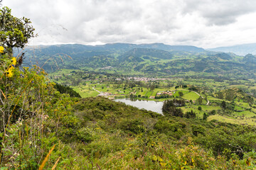 Fototapeta na wymiar Lake seen from a mountain called Pico San Pablo. It is located in Azuay, it is known as Lake Busa. The small town is observed from the mountain.