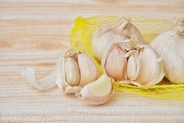 Fresh garlic cloves with wooden texture background