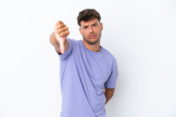 Young caucasian handsome man isolated on white background showing thumb down with negative...