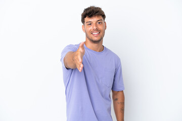 Young caucasian handsome man isolated on white background shaking hands for closing a good deal