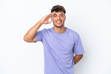 Fototapeta premium Young caucasian handsome man isolated on white background saluting with hand with happy expression