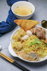 Chinese egg noodle topping slice roasted pork, fish balls, shrimp balls and wontons. Asian food style.