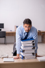 Young male employee and too much work in the office