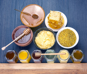 Hexagonal jars with different types and colors of fresh flower honey, spoon, pollen and comb honey. vitamin food for health and life