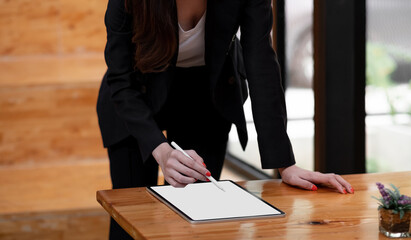 Close up hand of business woman working desk drawing on a white blank screen computer tablet