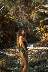 beautiful young sexy nude woman cover her body with palm leaf posing outdoors