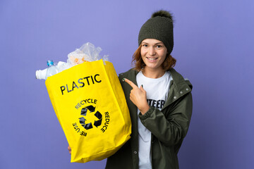 Young Georgian girl holding a bag full of plastic bottles to recycle pointing to the side to present a product