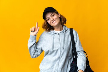 Young sport Georgian woman with sport bag over isolated background showing and lifting a finger in sign of the best