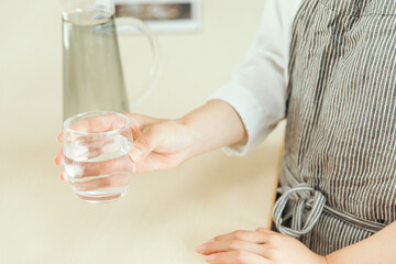 キッチンで透明なグラスを持つ手元　Kitchen cup hand