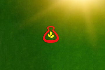 The bag is red, three yellow leaves, meaning gold on a green background. The concept of Financial savings. Investment of funds.