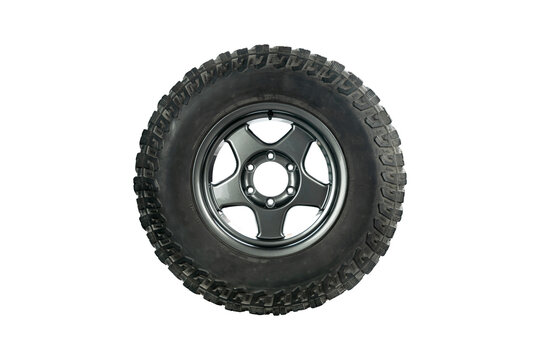 Side view of an all terrain tire with alloy wheel isolated on white background.