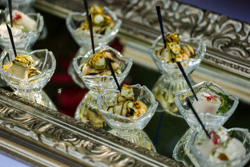 Appetizers, catering, snacks in glassware on the silver tray. High quality photo