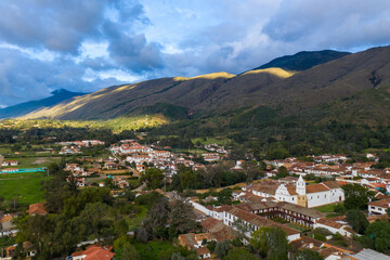Fototapeta na wymiar Aerial view of a colonial-style church and houses of the same style with mountains in the background in the town of Villa de Leyva. Colombia.